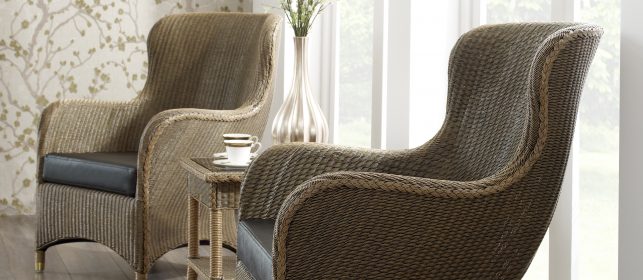 two cane furniture chairs situated between a table