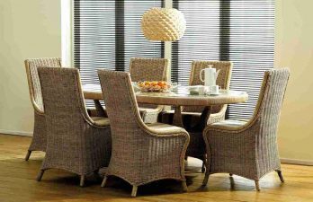 Cane furniture dining table set in a modern room with windows behind