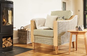 rattan cane armchair next to a fireplace